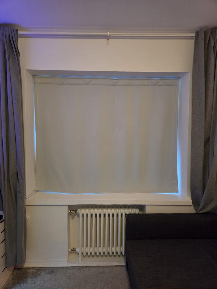 Rideaux lourds gris dans l’embrasure d’une fenêtre au-dessus d’un radiateur