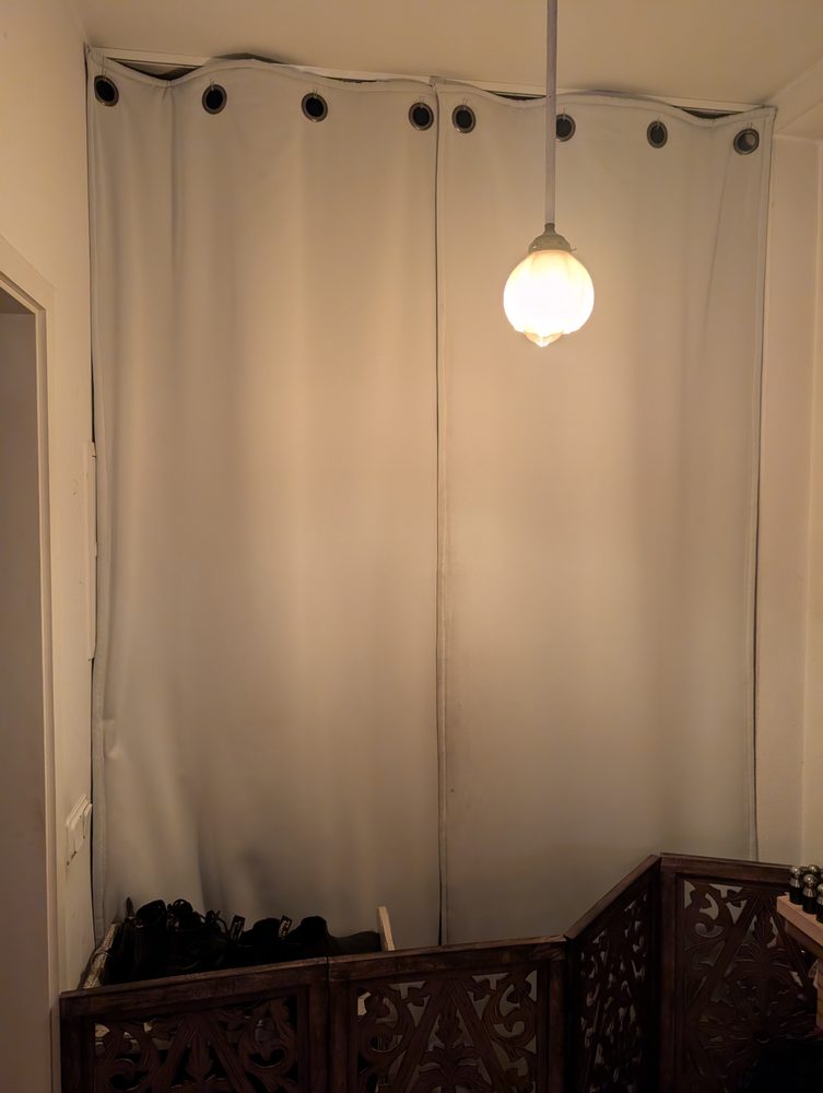 Rideau lourd crème devant la porte d’entrée d’un appartement