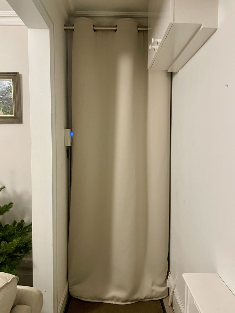 Rideau lourd beige tiré devant la porte d’entrée dans un couloir