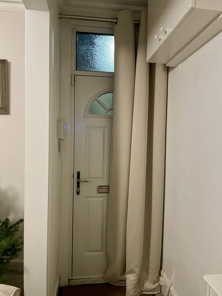 Rideau ouvert à côté d’une porte d’entrée vitrée