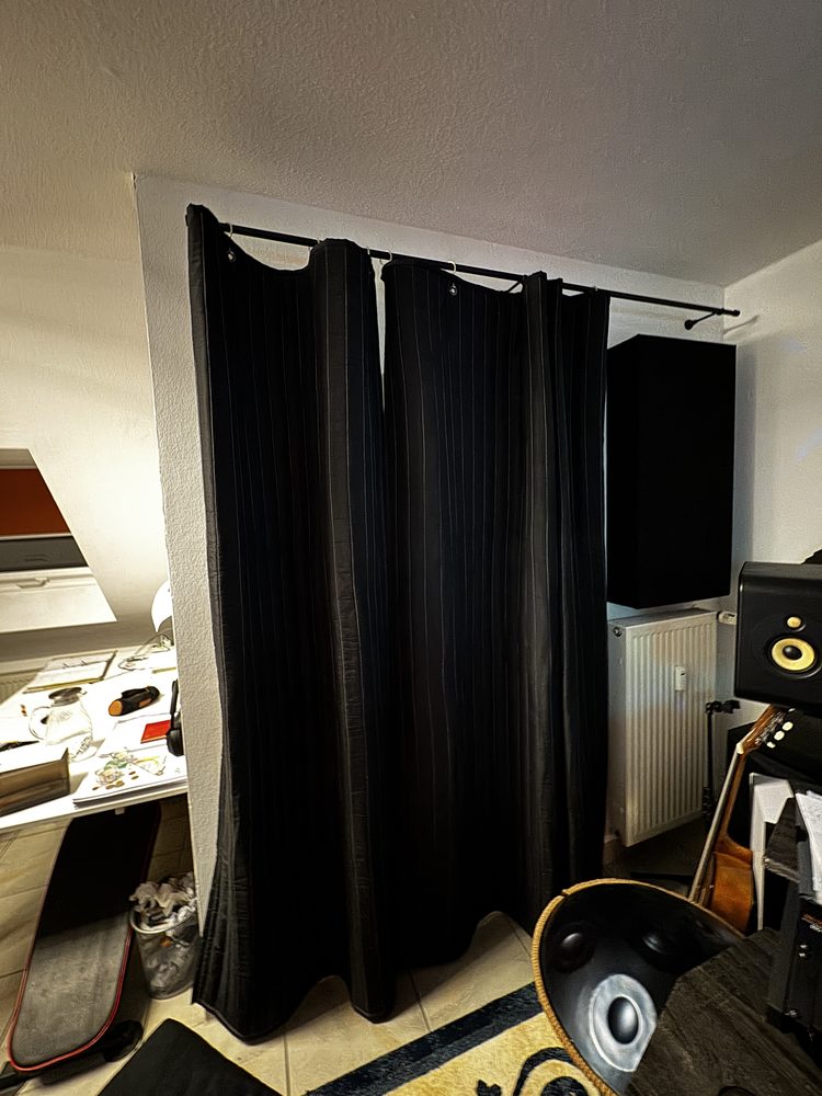 Rideaux SonicVoid noirs plissés à côté d’enceintes de studio
